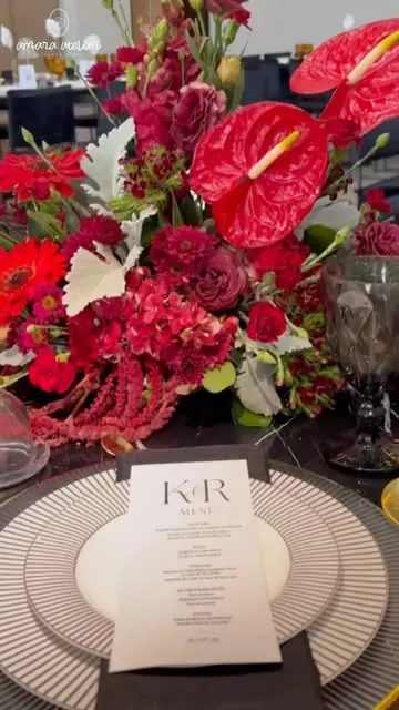 Mesa con flores rojas y menú personalizado
