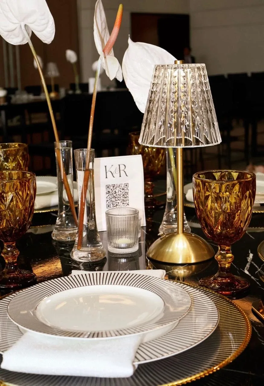 Mesa de evento con plato Nápoles, base dorada, copas Verona ámbar y lámpara de cristal